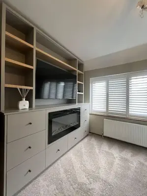 a living room with a tv and a dresser at Home by the Sea in Clacton-on-Sea