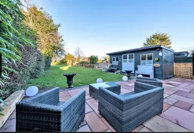 a backyard with two couches and a tiny house at Home by the Sea in Clacton-on-Sea