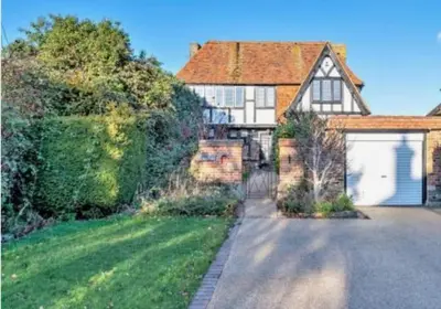 a large brick house with a white garage at Home by the Sea in Clacton-on-Sea