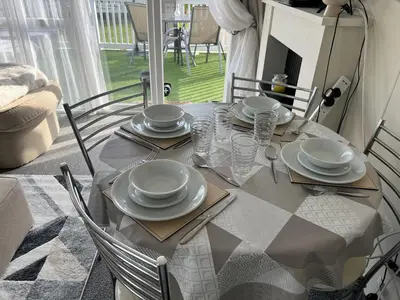 a dining room table with plates and glasses on it at Seaview Caravan 2 Bedroom Sleeps 6 -WiFi -Smart Tv in Colchester
