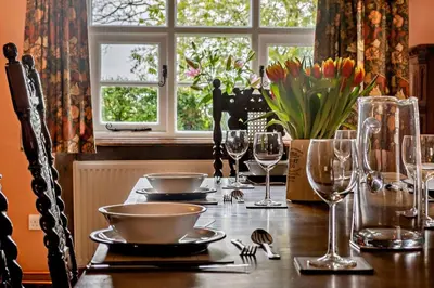 a table with glasses and plates on it with flowers at 3 Bed in Rumburgh oc-c27094 in Rumburgh