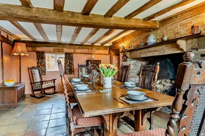 a dining room with a wooden table and a fireplace at 3 Bed in Rumburgh oc-c27094 in Rumburgh