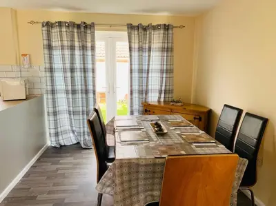 a dining room with a table with chairs and a window at Contractors and families welcome in Earith