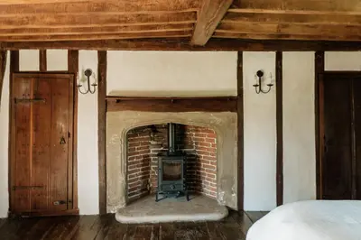 a brick fireplace in a room with a bed at Restaries at Paradise Farm in Halesworth