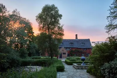 a building with a fountain in the middle of a garden at Restaries at Paradise Farm in Halesworth
