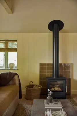 a living room with a fireplace and a couch at Restaries at Paradise Farm in Halesworth