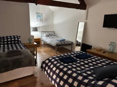 a living room with two beds and a mirror at The Dairy in Takeley