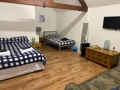 a room with two beds and a television in it at The Dairy in Takeley