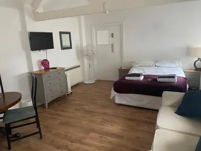 a bedroom with a bed and a desk and a couch at The Dairy in Takeley