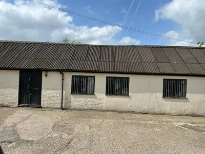 a white building with four windows and a roof at The Dairy in Takeley