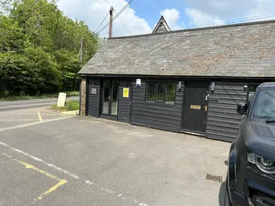 a car parked in a parking lot next to a building at The Dairy in Takeley