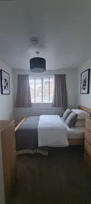 a bedroom with two beds and a large window at Carolines rooms in Cherry Hinton