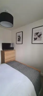a bedroom with a bed and a flat screen tv at Carolines rooms in Cherry Hinton