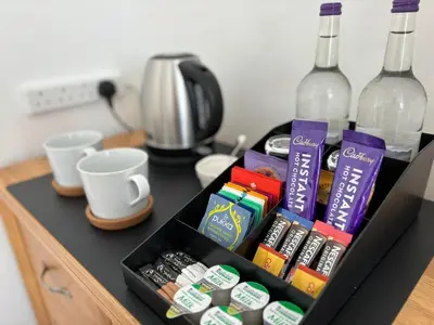 a drawer with a bottle of wine and some drinks at Carolines rooms in Cherry Hinton