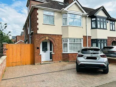 a car parked in front of a house at Carolines rooms in Cherry Hinton