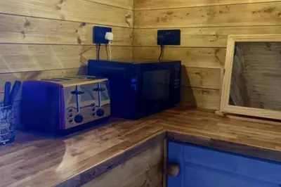 a room with a microwave and a mirror in a cabin at Inviting 1-Bed Cabin in Newmarket in Newmarket