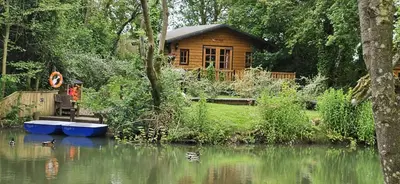 a wooden cabin on the side of a river at Inviting 1-Bed Cabin in Newmarket in Newmarket