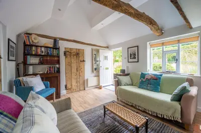 a living room with a couch and chairs at Myrtle Cottage 4 in Friston