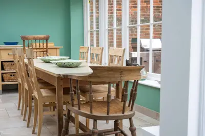 a dining room with a wooden table and chairs at Myrtle Cottage 4 in Friston