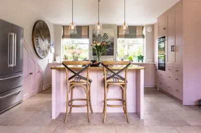 a kitchen with a large island with two bar stools at Little Fig in Aldeburgh