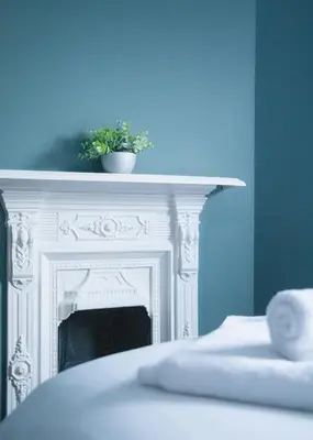 a white fireplace with a plant on top of it at Stylish 3x bed house in Soham in Soham