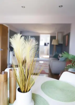 a vase filled with feathers sitting on a table at Stylish 3x bed house in Soham in Soham