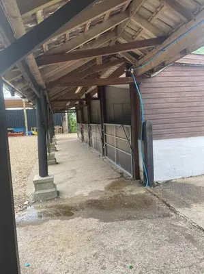 an empty building with a wooden roof and a garage at Ivy Cottage in Salters lode