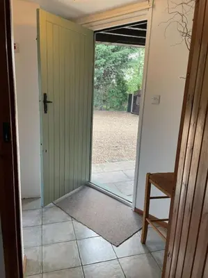 an open door to a room with a door to a yard at Ivy Cottage in Salters lode