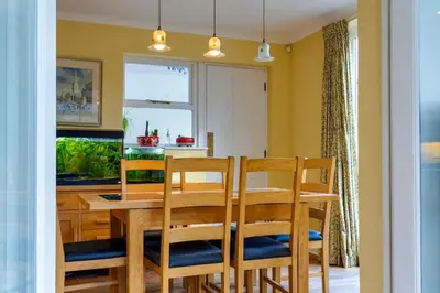 a dining room with a wooden table and chairs at Pass the Keys Spacious Victorian Home with Free Parking in Cambridge