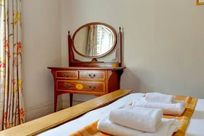 a bedroom with a bed with a dresser and a mirror at Pass the Keys Spacious Victorian Home with Free Parking in Cambridge