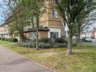 a brick house with trees in front of a street at Casa di Qeis a double bedroom ground floor flat with free parking in Chesterton