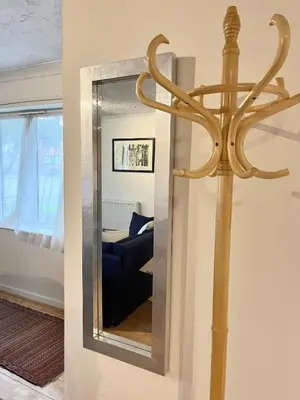 a mirror on a wall next to a living room at Casa di Qeis a double bedroom ground floor flat with free parking in Chesterton