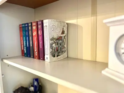 a group of books sitting on a shelf at Casa di Qeis a double bedroom ground floor flat with free parking in Chesterton