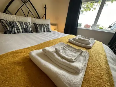 a bedroom with a bed with towels on it at 1 bed annex with extra sofa bed ideal for families and business guests in Littleport