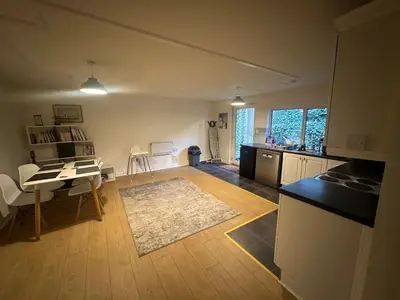 a kitchen and living room with a table and a dining room at 1 bed annex with extra sofa bed ideal for families and business guests in Littleport