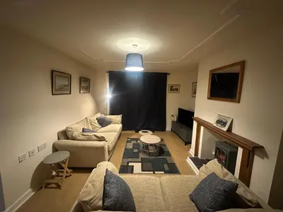 a living room with a couch and a fireplace at 1 bed annex with extra sofa bed ideal for families and business guests in Littleport