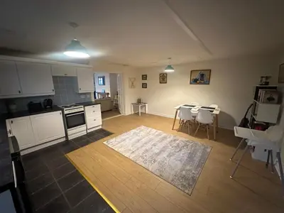 a kitchen with white cabinets and a table and chairs at 1 bed annex with extra sofa bed ideal for families and business guests in Littleport