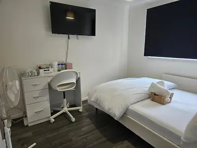 a bedroom with a bed and a desk and a chair at Jays-Rooms in Pitsea