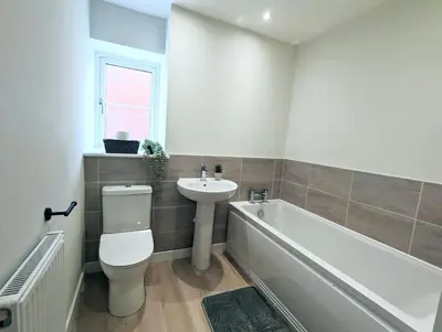 a bathroom with a toilet and a sink and a bath tub at 3-Bed, Sleeps 6, 3 Bath, Parking, WiFi in Watton