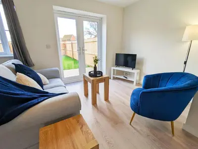 a living room with a blue couch and a tv at 3-Bed, Sleeps 6, 3 Bath, Parking, WiFi in Watton