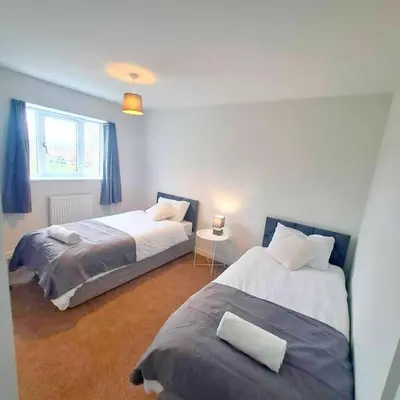 a bedroom with two beds and a window at 3-Bed, Sleeps 6, 3 Bath, Parking, WiFi in Watton