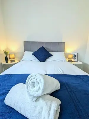 a bedroom with a bed with towels on it at 3-Bed, Sleeps 6, 3 Bath, Parking, WiFi in Watton
