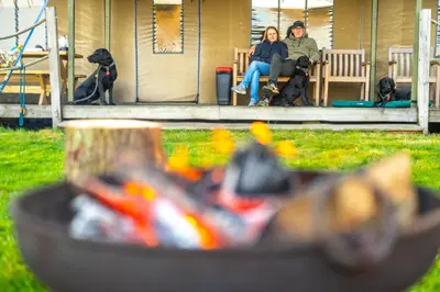 a man and woman sitting on a bench with two dogs at Cuckoo - Sweffling Hall in Rendham