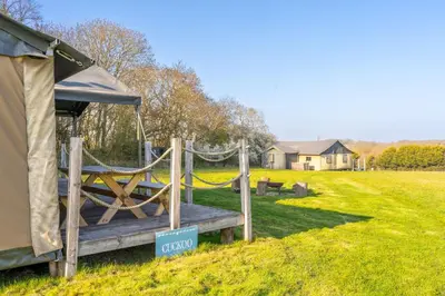 a gazebo with a hammock in a field at Cuckoo - Sweffling Hall in Rendham