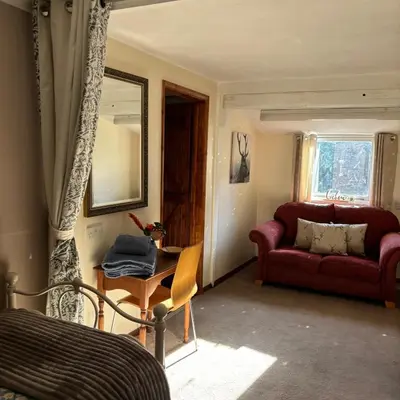 a living room with a red couch and a chair at 2 Bed Barn - Sleeps 4 - Pets - Parking - Wifi in Downham Market