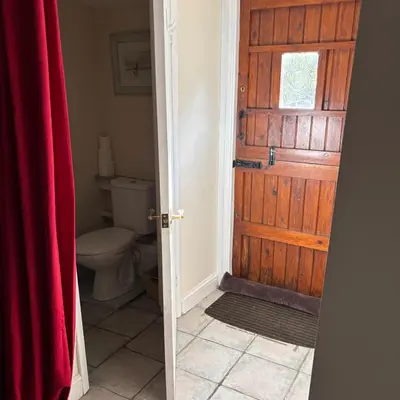 a bathroom with a toilet and a wooden door at 2 Bed Barn - Sleeps 4 - Pets - Parking - Wifi in Downham Market