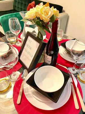a table with a bottle of wine and a bouquet of yellow roses at Luxe Smart Home - Basildon Serviced Accommodation - 7 Mins Walk To Basildon Town Centre, Hospital & Train Station in Basildon