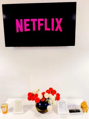 a vase with flowers on a table with a nittilus sign at Luxe Smart Home - Basildon Serviced Accommodation - 7 Mins Walk To Basildon Town Centre, Hospital & Train Station in Basildon