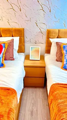 two beds sitting next to each other in a room at Luxe Smart Home - Basildon Serviced Accommodation - 7 Mins Walk To Basildon Town Centre, Hospital & Train Station in Basildon