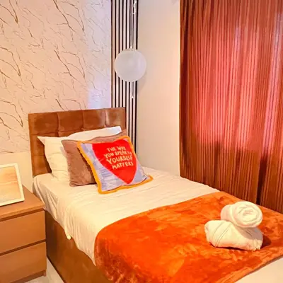 a bedroom with a bed with a pillow on it at Luxe Smart Home - Basildon Serviced Accommodation - 7 Mins Walk To Basildon Town Centre, Hospital & Train Station in Basildon